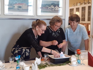 Inkeri ja Rauni laittavat arpoja Liisan ohjauksessa